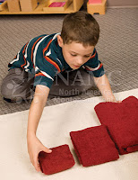 boy working on montessori practical life activity folding autism autistic children montessori works