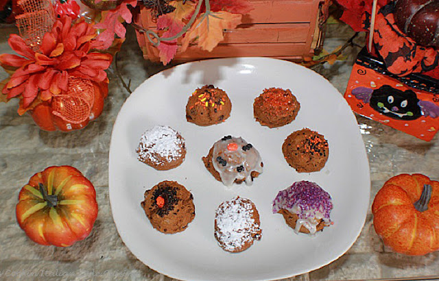 Easy Pumpkin Spice Chocolate Chip Cookies this recipe is how to make pumpkin spice chocolate chip cookies with a cake mix. Easy spice cake cookies are on a white plate. These are decorated with Halloween black, orange purple sprinkles and colored sugars. There are some pumpkin spiced chocolate chip cookies just dusted with powdered sugar and some frosted with cream cheese frosting.