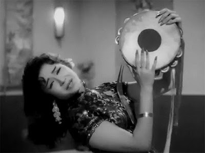 A young Helen wearing a cheongsam and shaking a tambourine