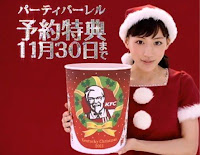 Japanese advertisement for Christmas at Kentucky Fried Chicken A young Japanese woman in a Santa-style outfit holding a bucket of Kentucky Fried Chicken. There is a red background with white Japanese lettering.