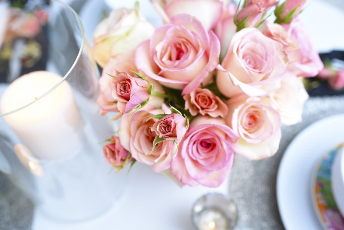 White dinnerware, gold flatware, and a simple floral and candle tablescape make a small space look grand and luxe for entertaining. So many great ideas in this post via monicawantsit.com