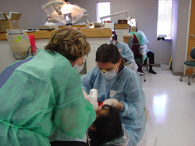 Two dental students looking at a child's teeth