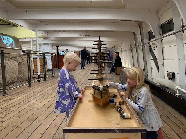 2 children playing with a wooden boat