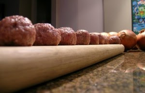 Swedish Meatballs laying on a cutting board ready to be fried.