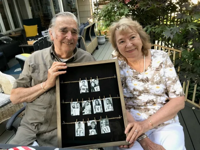Mom and Dad holding frame with photos