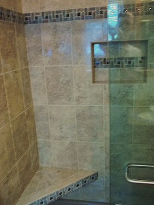 Pinwheel tile accent on seat, niche and walls for shower surround