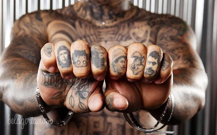 Un joven con tatuajes de dibujos en los dedos