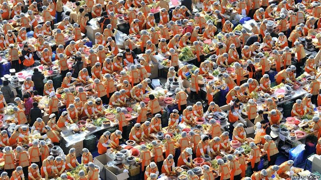 Some 2,000 South Korean volunteers make 140 tonnes of kimchi, a traditional dish of spicy fermented cabbage and radish, in a park outside the metropolitan government building in Seoul. City officials will hand out kimchi to about 14,000 poor households in an event marking the start of the winter season.