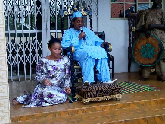 Alaafin of Oyo hold court with market women and wife by his side.