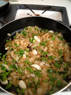 Pan with diced onions, green peppers, and garlic cloves