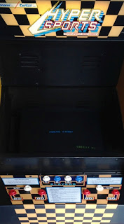Hyper Sports, mueble Detalle de una máquina de Konami Hyper Sports. La imagen muestra la pantalla (insert coin), tres botones de acción para cuatro jugadores, dos a dos como máximo
