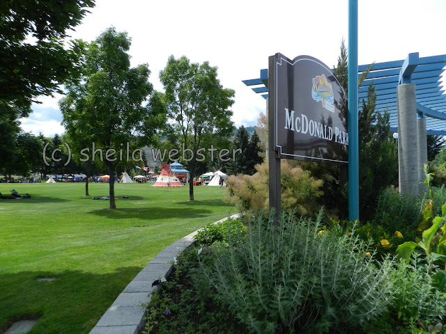 The sign of McDonald Park with the tents and booths set up across the park.
