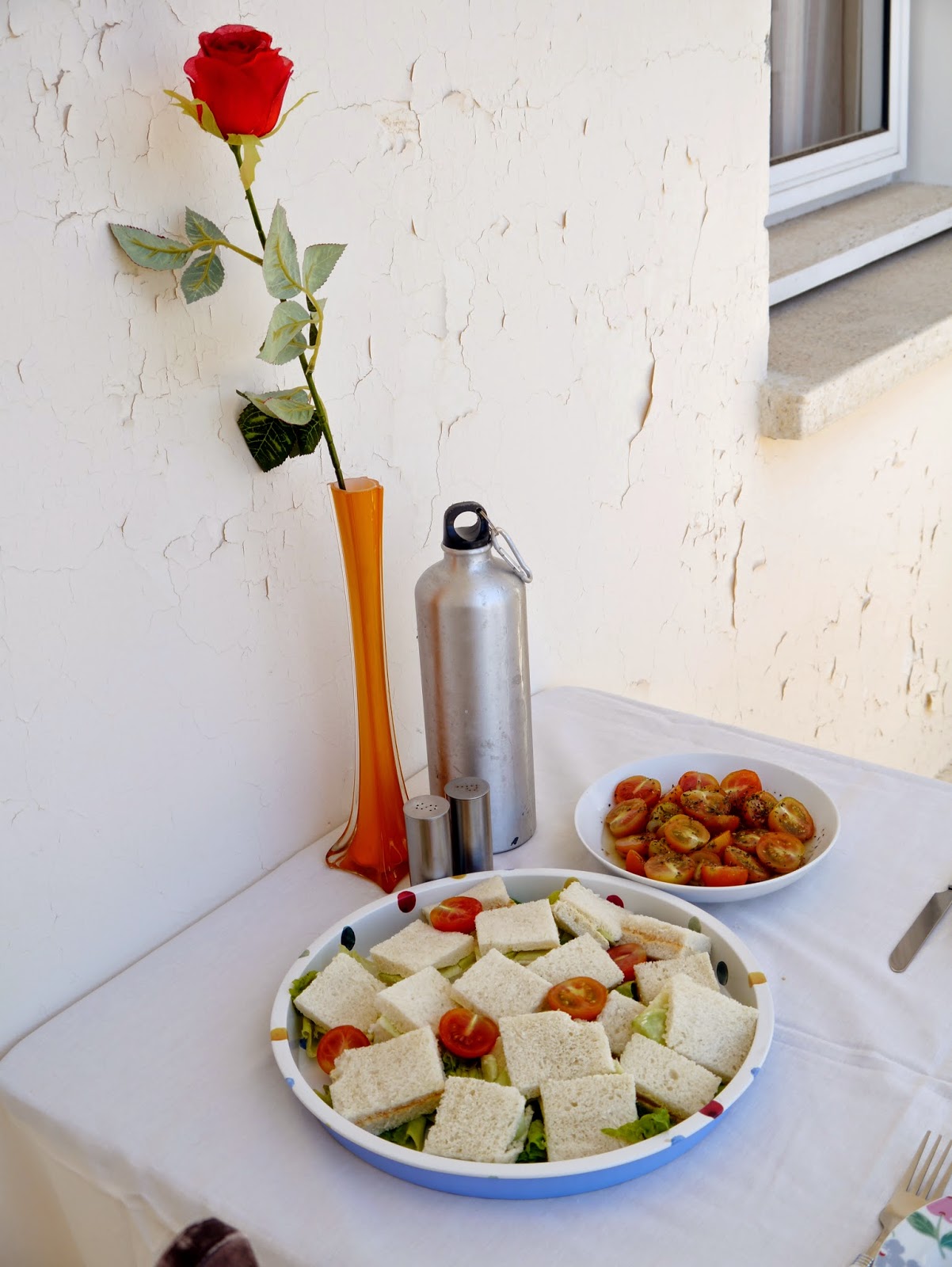 sandwiches, tomatoes and fake rose in vase