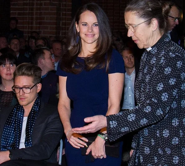 Princess Sofia, Sara Hellqvist and Lina Hellqvist at Christmas concert in Stockholm. Princess wore PRADA Knee length dress, Grece clutbag, gold bracelet, diamond rings and diamond gold earrings