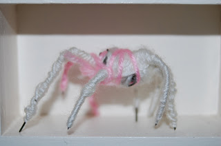 en vit och rosa spindel av metall och garn