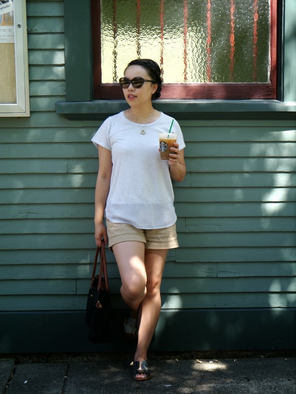 Simple summer chic in a silk/cotton powder blue tee, khaki shorts, silver sandals, and cat-eye sunnies