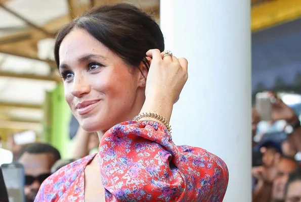 Meghan Markle wore Figue Frederica printed ruffle dress and Castañer Carina Black canvas wedge, and she wore Karen Walker gold stud earrings