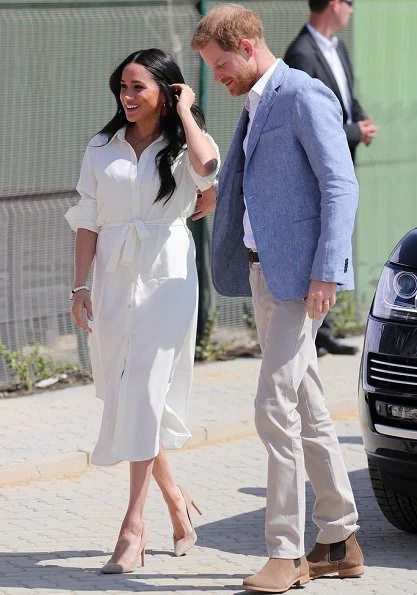 Meghan Markle wore a white belted shirt dress, and Madewell stone and tassel earrings, Stuart Weitzman suede pumps