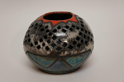 Beautiful pierced ceramic pottery vessel with bright raku glazes.