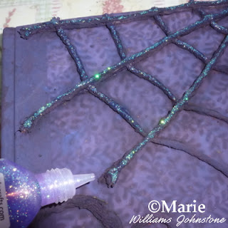 Applying glitter glue over the raised pattern