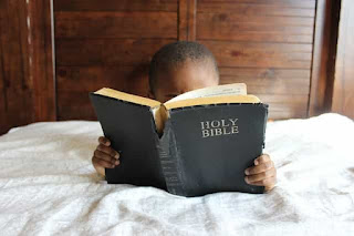 young child reading the bible