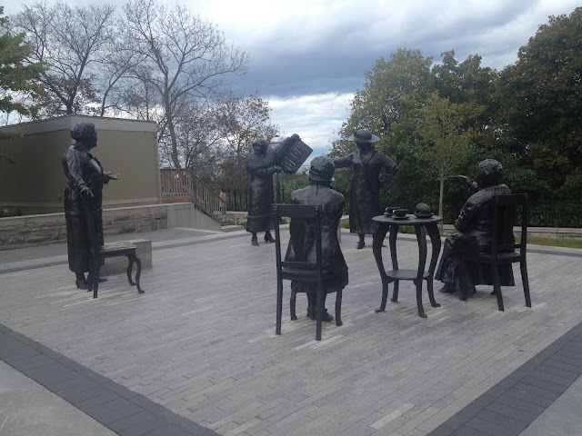Essas estatuas representam as mulheres ativistas que lutaram para que a mulher também tenha seu espaço no senado. A que está de pé segura um livro que diz “mulheres são pessoas” com a data de 18 de outubro de 1929.