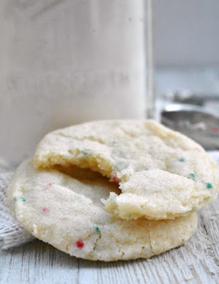 These sweet sugar jars are loaded with festive sprinkles that are ready to be baked into sugar cookies. They make great gifts for teachers, friends or the big man himself! couple of sprinkle sugar cookies one with a bite taken out