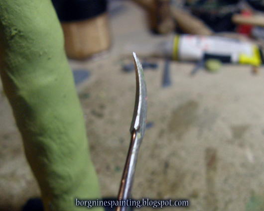 Closeup on the sculpting tool - looking like an inverted, tiny scythe.