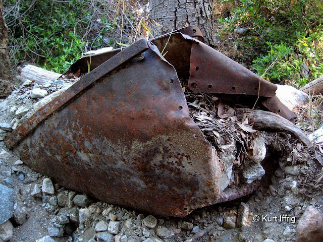 This is an old ore cart washed down from Allison Mine. There is another one at the San Gabriel Dam. This badly bent ore cart can be found in Allison Gulch, miles below the mine.