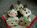 Karácsonyi csokicseppes kókuszos muffin, aminek a tetején kókusztejes krém és kókuszreszelék van, mikulásos, hóemberes és angyalkás csokival díszítve.