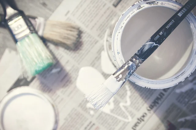 white paint can and brush