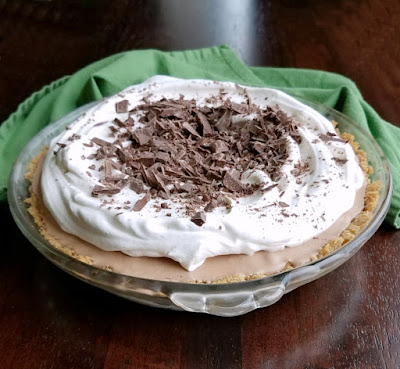 whole frozen mint meltaway pie (aka frango mint pie) topped with whipped cream and chopped frango mints