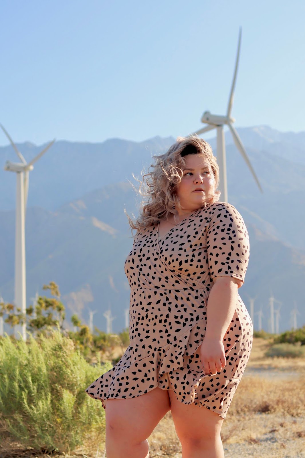 Chicago Plus Size Petite Fashion Blogger, YouTuber, and model Natalie Craig, of Natalie in the City, reviews Pink Clove's mini wrap dress and attends Her Conference in Los Angeles. palm springs windmills, best places to take photos in palm springs