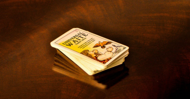 Un jeu de tarot divinatoire en anglais posé sur une table de bois sombre