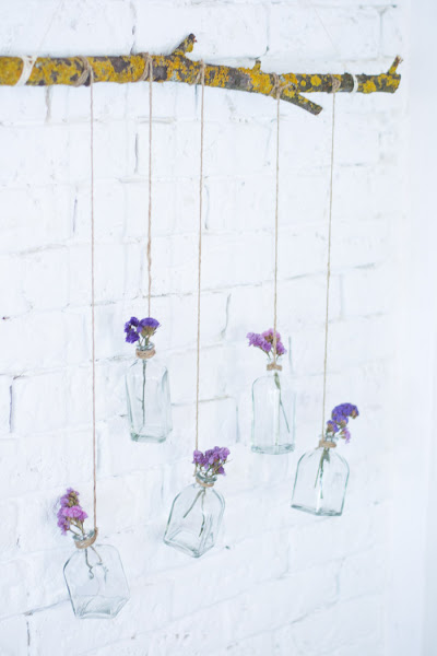 Rama con botellas de cristal y flores