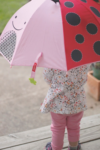 little L wearing Zutano holding her Skip Hop Zoobrella review of ladybug Zoobrella umbrella by Skip Hop and Zutano kids' clothing