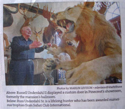 Newspaper photo of an older man among taxidermied antelopes and lions