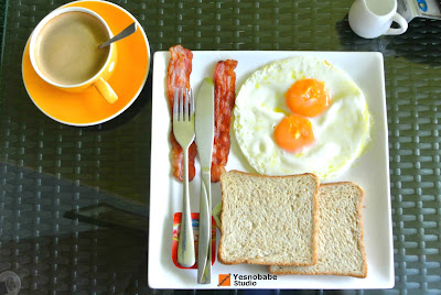 The English breakfast with bacon, eggs and breads in a plate with a cup of coffee in a cafe in Koh Tao, Thailand