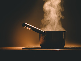 Cazuela al fuego con agua y vapor Cazuela al fuego con agua y vapor