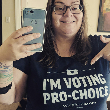 image of me standing in a mirror, from mid-torso up, pointing at the text on my t-shirt, which reads: 'I'M VOTING PRO-CHOICE | WolfForPA.com'