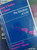 From Clocks to Chaos: The Rhythms of Life, by Leon Glass and Michael Mackey, superimposed on Intermediate Physics for Medicine and Biology.