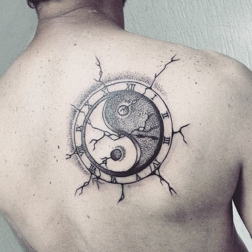 Preto Yin Yang tatuagem com tinta na parte de trás, que retrata um símbolo do Yin Yang que aparentemente caiu sobre a pele da pessoa com toda a pele rachaduras fechou em torno dele.