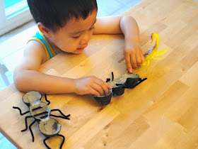 child playing with egg carton ant and scorpian