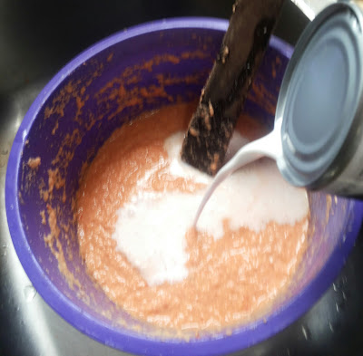 Adding coconut milk to make moi moi