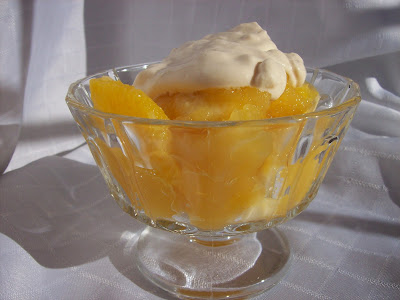 Orange Jelly Dessert in bowl with dollop of cream.