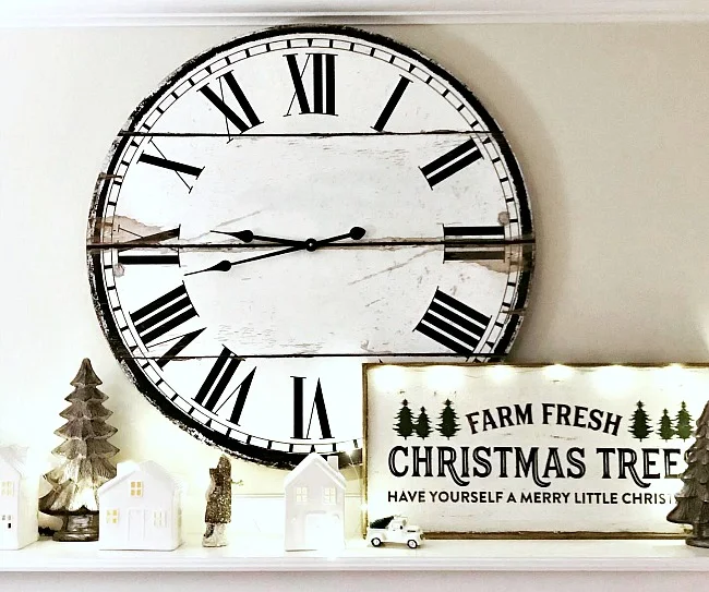 Christmas mantel with houses, clock and trees