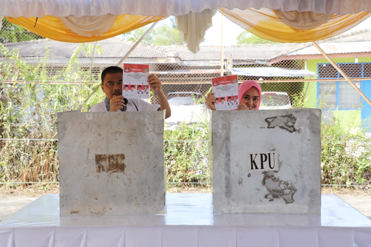 Bupati Asahan Taufan Gama Simatupang dan istri saat dibilik suara. Bupati Asahan Taufan Gama Simatupang dan istri saat dibilik suara.