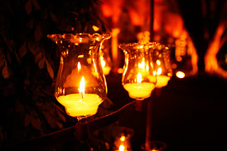 Imagen de varias velas encendidas en la oscuridad
