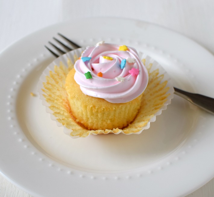 Cupcake de vainilla decorado, presentado sobre un plato para ser degustado