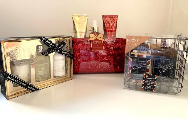 3 beauty gift sets including one in gold, one in a sparkly red bag and a men's set in a wire crate